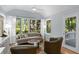 Comfortable living room featuring a large window, hardwood floors, neutral tones, and an adjacent door at 2766 Old Oak Walk, Seabrook Island, SC 29455