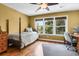 Bedroom with hardwood floors, ceiling fan and large windows overlooking nature at 29 Morrison Ave, McClellanville, SC 29458