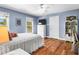 Bright bedroom featuring two windows, hardwood floors, and a cozy bed at 29 Morrison Ave, McClellanville, SC 29458
