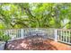 Wooden deck features table and chairs nestled among lush green trees at 29 Morrison Ave, McClellanville, SC 29458
