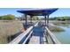 Scenic dock featuring a covered structure with seating and a swing, offering serene water views at 29 Morrison Ave, McClellanville, SC 29458