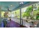 Inviting front porch features a ceiling fan, hanging lantern lights, and a view of lush greenery at 29 Morrison Ave, McClellanville, SC 29458