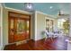 Charming front porch with stained wood floor, ceiling fan, seating area, and front door at 29 Morrison Ave, McClellanville, SC 29458