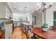 Spacious kitchen features stainless appliances, an island, and a dining area with charming chandelier at 29 Morrison Ave, McClellanville, SC 29458