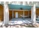 Relaxing covered patio with a hammock, ceiling fan, and convenient access door enhancing outdoor living at 29 Morrison Ave, McClellanville, SC 29458