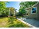 Spacious backyard features a brick home, lush lawn, mature trees, and patio area at 3 Lord Ashley Dr, Charleston, SC 29407