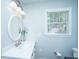 Bright bathroom features a white marble vanity, oval mirror, and natural light from the window at 3 Lord Ashley Dr, Charleston, SC 29407