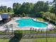 Aerial view of a large, uniquely shaped community pool with ample seating surrounded by lush greenery at 344 Flyway Rd, Goose Creek, SC 29445