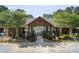 Inviting pool house entrance features a peaked roof, black iron gates, and is surrounded by colorful landscaping at 344 Flyway Rd, Goose Creek, SC 29445
