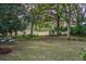 Lush green backyard with mature trees and outdoor seating, perfect for relaxing and enjoying the peaceful surroundings at 3567 Somerset Hills Ct, Mount Pleasant, SC 29466