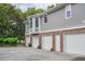 View of the home's four-car garage with light gray vinyl siding and brick facade and bay window at 3567 Somerset Hills Ct, Mount Pleasant, SC 29466