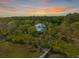 Aerial view of home nestled in a lush, wooded area at sunset at 4386 Park Island Rd, Hollywood, SC 29449