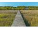 Inviting wooden walkway leading to waterfront, offering stunning views of marsh at 4386 Park Island Rd, Hollywood, SC 29449