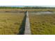 Long wooden dock stretching across marsh, offering serene access to river at 4386 Park Island Rd, Hollywood, SC 29449