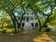Two story home with stairs and porch with mature trees in front, with nice green lawn at 4386 Park Island Rd, Hollywood, SC 29449
