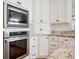 Bright kitchen featuring white cabinets, granite counters, and stainless steel appliances at 4386 Park Island Rd, Hollywood, SC 29449
