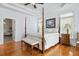 Spacious main bedroom with tray ceilings, hardwood floors, large windows, and a four-poster bed at 4386 Park Island Rd, Hollywood, SC 29449