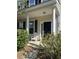 Charming front porch featuring classic columns, a black front door, and complemented by lush green bushes at 4816 Cane Pole Ln, Summerville, SC 29485