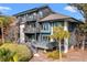 View of condo's exterior with private balconies, lush landscaping, outdoor patio, and large windows at 4947 Green Dolphin Way, Kiawah Island, SC 29455