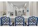 Modern kitchen features white cabinetry, stainless steel appliances, and a breakfast bar with stylish blue chairs at 4947 Green Dolphin Way, Kiawah Island, SC 29455