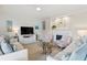 Bright living room featuring comfortable sofas, floral accent chairs, and a modern fireplace at 4947 Green Dolphin Way, Kiawah Island, SC 29455