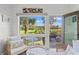 Bright sunroom with wicker chairs offering picturesque views of the pond, golf course and sunny sky at 4947 Green Dolphin Way, Kiawah Island, SC 29455