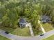 Aerial view of a home with long driveway and grassy front yard on a tree-lined street at 5005 Buckland Trl, Ridgeville, SC 29472