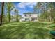 Expansive green backyard with a well-maintained lawn, trees, and a view of the house features a tranquil, outdoor space at 5005 Buckland Trl, Ridgeville, SC 29472
