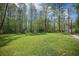 Spacious backyard features a lush lawn, tall trees, and playground equipment to offer space for recreational activities at 5005 Buckland Trl, Ridgeville, SC 29472