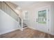Stylish entryway featuring wood floors, stairs with black rails, and white front door at 5005 Buckland Trl, Ridgeville, SC 29472