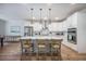 Modern kitchen features white cabinets, stainless steel appliances, an island with seating, and pendant lighting at 5005 Buckland Trl, Ridgeville, SC 29472