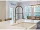 Kitchen island close up featuring a farmhouse sink and spring faucet, with a dining area visible in the background at 5005 Buckland Trl, Ridgeville, SC 29472
