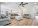 Open-concept living room with hardwood floors, neutral sofas, and a view into the kitchen and dining area at 5005 Buckland Trl, Ridgeville, SC 29472