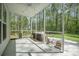 Relaxing screened porch features a ceiling fan, neutral furniture set, and an opening to the lawn and woods at 5005 Buckland Trl, Ridgeville, SC 29472