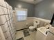 Well-lit bathroom featuring white fixtures, tiled walls, and a black and white patterned floor at 502 May St, Saint George, SC 29477