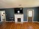 Spacious living room featuring a brick fireplace, a hardwood floor, and backyard access at 502 May St, Saint George, SC 29477