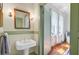 Traditional bathroom with pedestal sink, soft lighting, and sheer curtains in the window, creating a serene atmosphere at 503 W Carolina Ave, Summerville, SC 29483