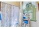 Traditional bathroom featuring patterned shower curtains and a window with a stained glass accent at 503 W Carolina Ave, Summerville, SC 29483