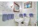 Vintage bathroom featuring a unique pedestal sink, floral wallpaper, and decorative accents at 503 W Carolina Ave, Summerville, SC 29483