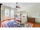 Spacious bedroom featuring a four-poster bed, ceiling fan, and hardwood floors with a colorful area rug at 503 W Carolina Ave, Summerville, SC 29483