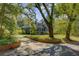 Charming home with mature trees, brick accents, and a circular driveway, offering curb appeal and natural beauty at 503 W Carolina Ave, Summerville, SC 29483