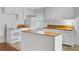 Bright kitchen features white cabinets, an island with butcher block top, and a classic white appliance package at 503 W Carolina Ave, Summerville, SC 29483