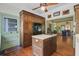 Well-lit kitchen showcasing the hardwood cabinets, stainless refrigerator, and central island with cooktop at 503 W Carolina Ave, Summerville, SC 29483