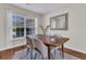 Sunlit dining area with a wooden table, soft chairs, and a view through sheer window curtains at 5033 Carrington Ct, Summerville, SC 29485