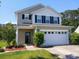 Charming two-story home boasts a well-manicured lawn, neutral siding, black shutters and a two car garage at 515 Flycatcher Dr, Goose Creek, SC 29445