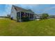 The backyard features a screened in porch and a well-maintained lawn at 554 Tranquil Waters Way, Summerville, SC 29486
