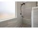 Modern shower featuring sleek gray tile, pebble flooring, and a handheld shower head at 554 Tranquil Waters Way, Summerville, SC 29486
