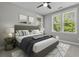 This primary bedroom features a ceiling fan, and natural light from the windows at 5554 Colonial Chatsworth Cir, North Charleston, SC 29418