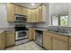 Bright kitchen boasts stainless steel appliances, granite countertops, and light wood cabinetry at 5554 Colonial Chatsworth Cir, North Charleston, SC 29418