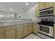 Kitchen featuring granite countertops, stainless steel oven, microwave, and light wood cabinets at 5554 Colonial Chatsworth Cir, North Charleston, SC 29418